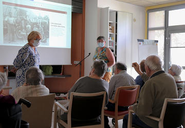 Un résident raconte l'histoire de son père pendant l'atelier "Les albums de notre histoire", en présence d'Isabelle Rivière. ©CD85